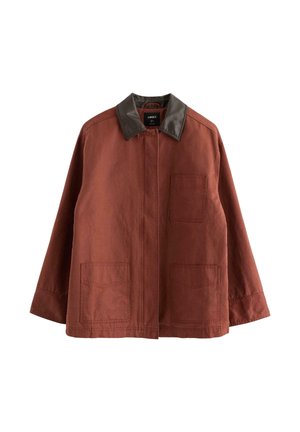 Giacca marrone ruggine con colletto in pelle marrone scuro e tre tasche applicate frontali, vestibilità leggermente oversize.