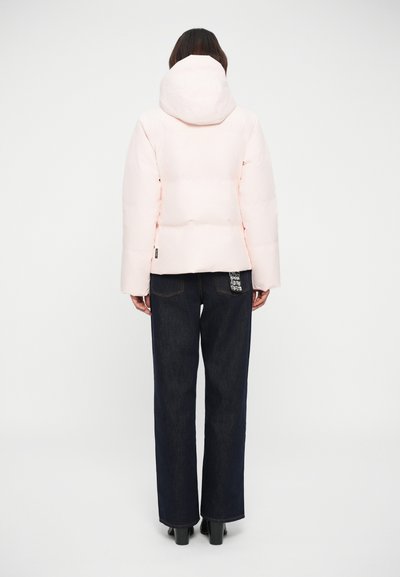 Light pink puffer jacket with a hood, featuring a quilted design. Paired with dark denim wide-leg trousers and black heeled boots.