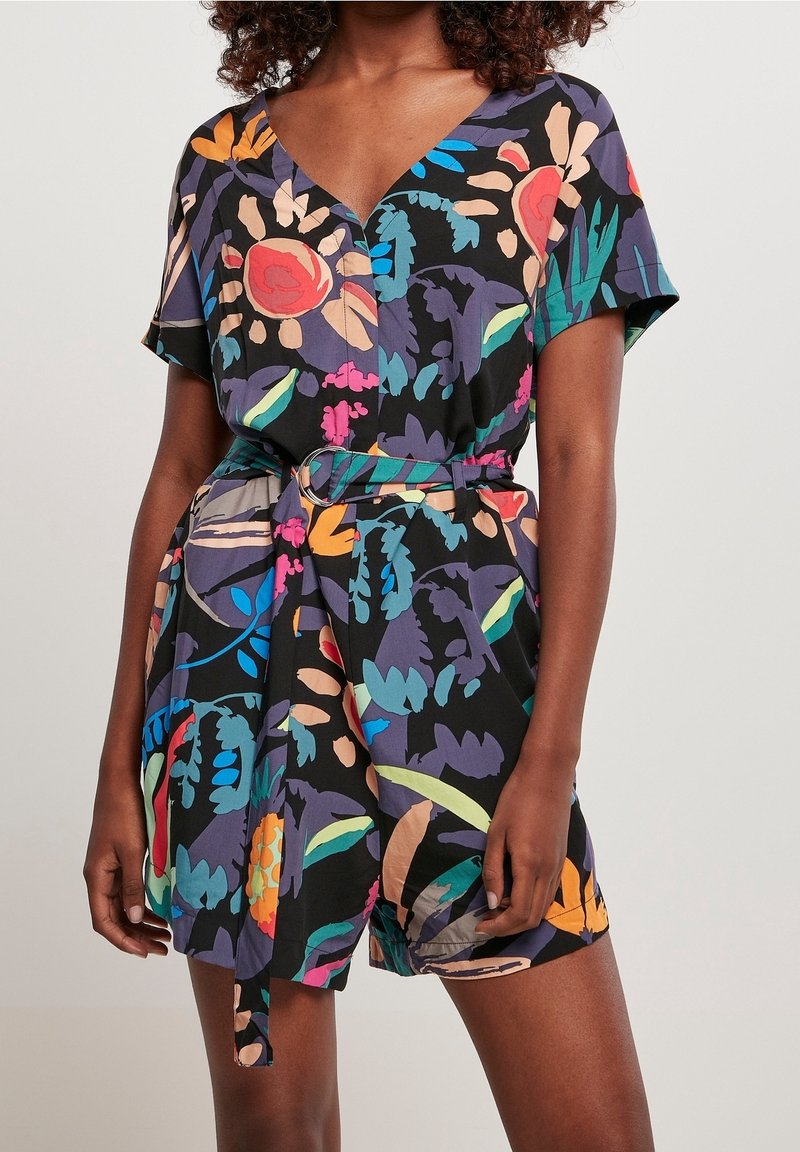 Combinaison à motif floral avec un décolleté en V, des manches courtes, une taille cintrée avec une ceinture, et un fond noir agrémenté de couleurs vives.