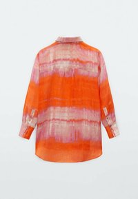 Farverig, letvægts skjorte med knaplukning i orange med pink og creme tie-dye mønstre. Har krave og lange ærmer med knapmanchetter.