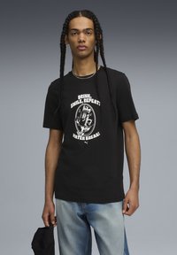 Black cotton t-shirt with short sleeves, featuring a white graphic text design that reads "DRINK, SMILE, REPEAT! WATER BREAK!"