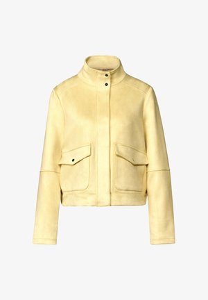 Veste cropped en daim jaune avec un col montant, deux poches avant et des boutons-pression noirs pour la fermeture. Texture lisse, design structuré.
