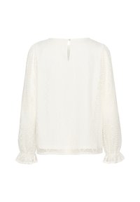 White blouse with long sleeves, textured patterns, and ruffled cuffs. Features a keyhole back closure for added detail.