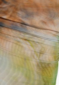 Venytetty kangas, jossa on aaltoileva kuvio maanläheisissä ruskean, vihreän ja harmaan sävyissä, esittelee sileän pinnan ja kerroksellisia poimuja.