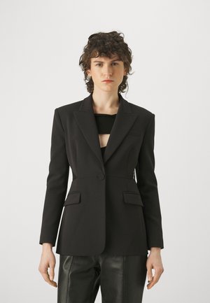 Blazer nero strutturato con chiusura a un bottone, due tasche frontali e tessuto morbido. Presenta un colletto a notched e una vestibilità su misura.