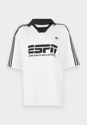 Bijela košulja kratkih rukava s crnim ovratnikom, tri crne pruge na rukavima i izraženim crnim tekstom "ESPN" i "NEMA MJESTA KAO ŠTO JE SPOTS."