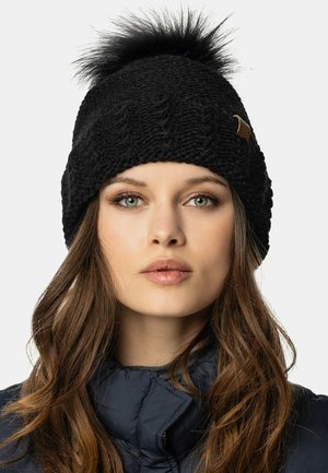 Berretto a maglia nera con un motivo testurizzato e un pom-pom in pelliccia sintetica sulla sommità. Presenta un piccolo cartellino di pelle marrone come dettaglio.