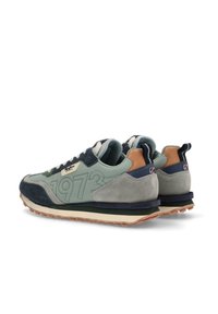 Zapatillas verdes y marino con un empeine de ante texturizado, que presentan un gran detalle "1973", acentos marrones y una suela de goma.