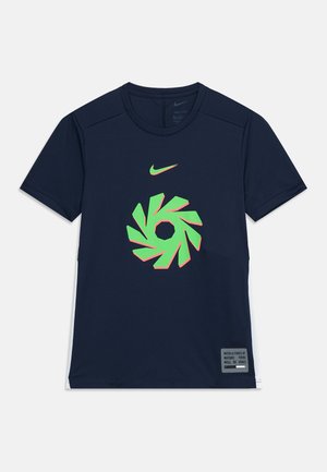 T-shirt de sport Nike bleu marine à manches courtes avec un graphisme circulaire vert fluo et rose et une petite étiquette de texte en bas à droite sur le devant.