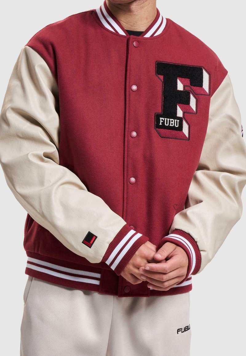 Veste universitaire rouge avec manches en cuir crème, logo brodé "F", col et poignets côtelés rayés. Boutons assortis à la couleur du tissu.