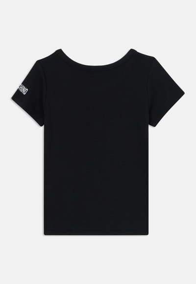 Camiseta de algodón negra de manga corta, con cuello redondo y textura acanalada. Presenta un sutil logo blanco en la manga izquierda.