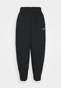 Svarta Nike träningbyxor med elasticitet i midjan och smalna ben, som har en vit Nike swoosh-logotyp på vänster lår.