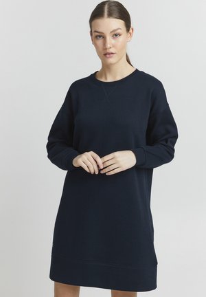 Robe-sweat bleu marine en tissu doux, à col rond et manches longues. Présente des poignets côtelés et une coupe décontractée avec un ourlet subtil.