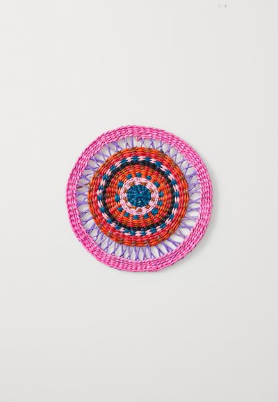 Round woven trivet composed of colorful synthetic fibers. Features concentric patterns in red, pink, blue, and orange, with a textured surface.