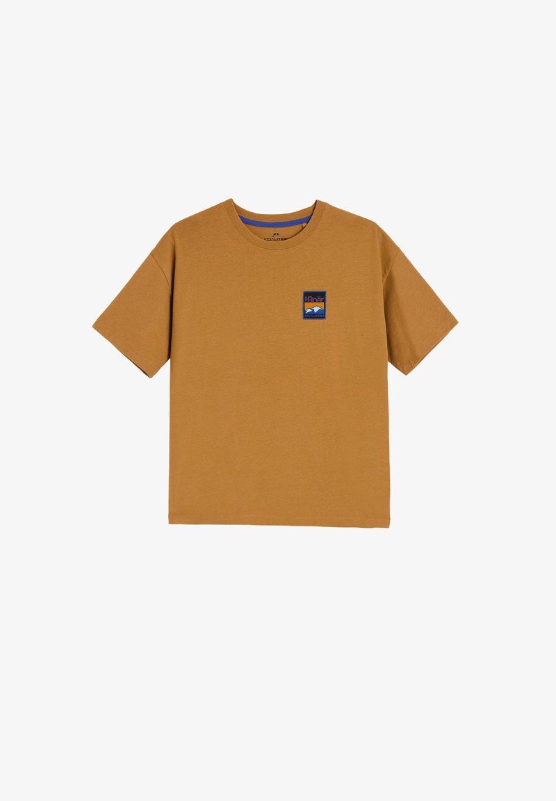 Brązowy bawełniany t-shirt z krótkim rękawem, z małą niebiesko-białą łatką logo po lewej stronie w pobliżu dekoltu.