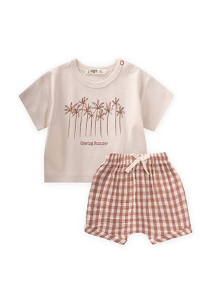 Camiseta de algodón beige claro con diseño de palmera y el texto "Deseando el Verano" combinada con pantalones cortos de cuadros marrones con cintura elástica.