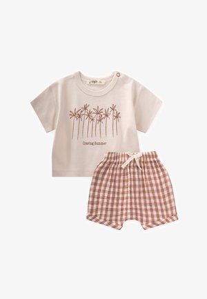 Camiseta de algodón beige claro con diseño de palmera y el texto "Deseando el Verano" combinada con pantalones cortos de cuadros marrones con cintura elástica.