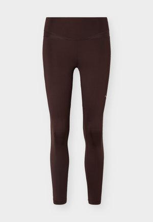 Σκούρα καφέ γυναικεία κολάν ψηλόμεσα με επίπεδες ραφές και ελαστικό ύφασμα που εφαρμόζει στενά, εμφανιζόμενα σε λευκό φόντο.