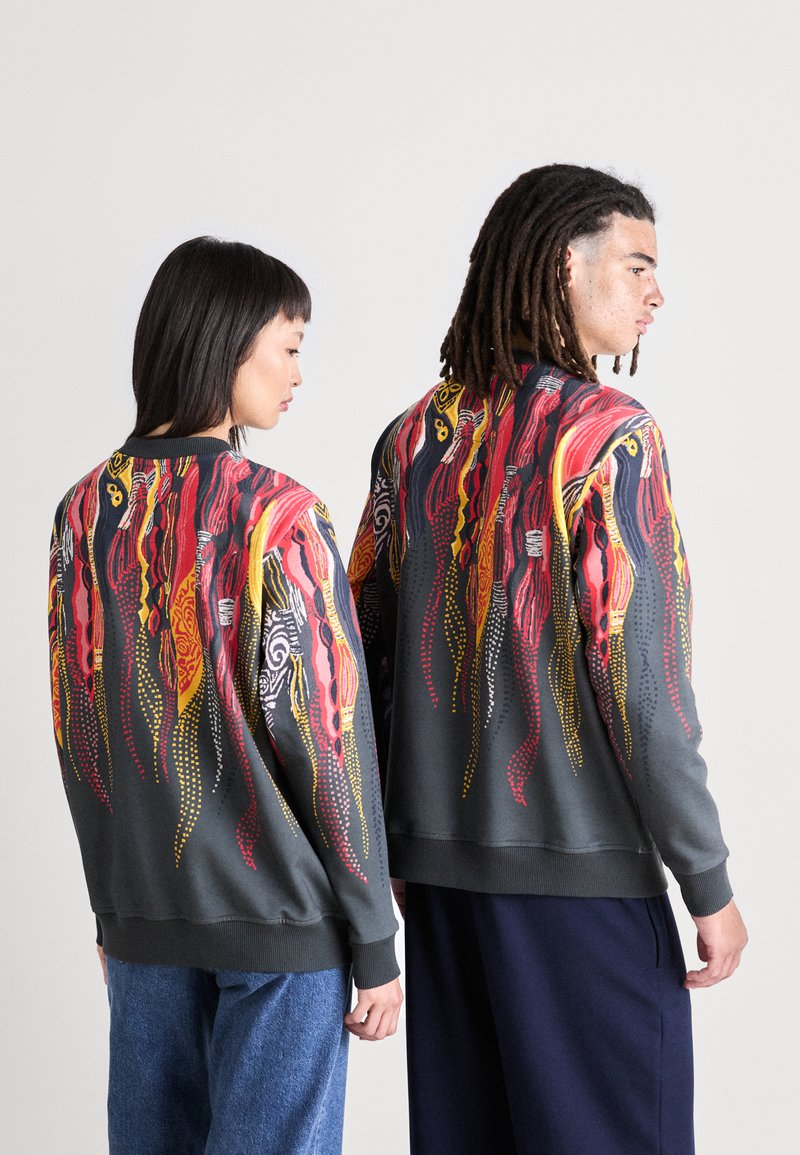 Grijze sweatshirt met een levendig abstract ontwerp in rood, geel en zwart met gestipte accenten. Geribde manchetten en zoom. Unisex stijl.