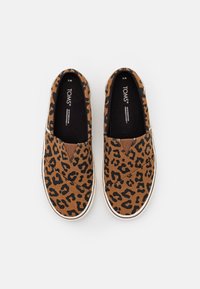 Bruna leopardmönstrade slip-on skor med vit gummisula och elastiska sidopaneler. Överdel i mjukt tyg med en slät innersula.