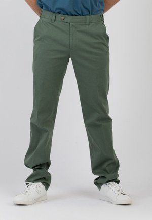 Chinos verdi in cotone con design a gamba dritta, dotati di un cinturino standard e tasche frontali, abbinati a sneaker bianche.