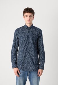 Navy shirt with a floral white pattern, button-down collar, long sleeves, and blue denim jeans. The fabric appears smooth and lightweight.