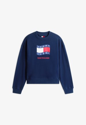 Marineblå sweatshirt med Tommy Jeans-logo i hvid, rød og blå samt rød tekst nedenunder, der siger "Stolt af at være Jeans!"