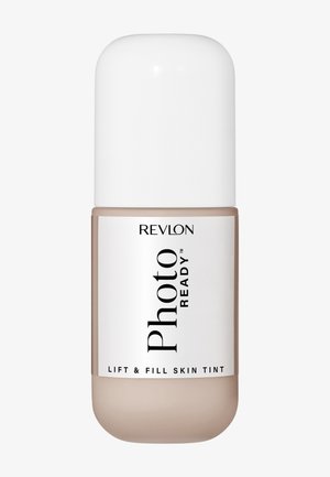 Revlon PhotoReady Lift & Fill Skin Tint i en rund flaske med hvid hætte og etiket på en lysebeige baggrund.