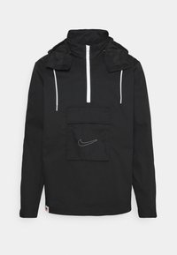 Black windbreaker jacket with a high collar, white zipper, and front pocket. Features a white Nike logo embroidered on the pocket.