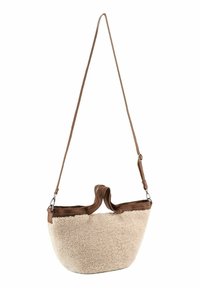 Beige schapenvacht tas met een afgeronde vorm, bruine leren accenten, een enkele verstelbare schouderband en een handvat om te dragen.