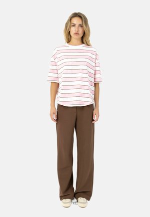 Gestreept T-shirt in roze en wit, met korte mouwen en een zak, gecombineerd met losse bruine broek en lichte schoenen.