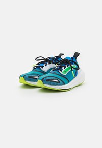 Sportovní boty s modro-zeleným designem, síťovaným svrškem, černými tkaničkami a texturovanými akcenty na podrážce. Lehká konstrukce.