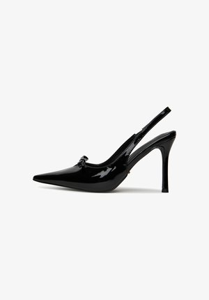 Fekete lakkozott bőr slingback sarokcipő hegyes orral és masnis díszítéssel. Stiletto sarokkal és sima, fényes felülettel rendelkezik.