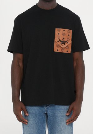 Camiseta de algodón negra con un bolsillo marrón con patrón y detalles de logo en relieve. Mangas cortas y un corte holgado.