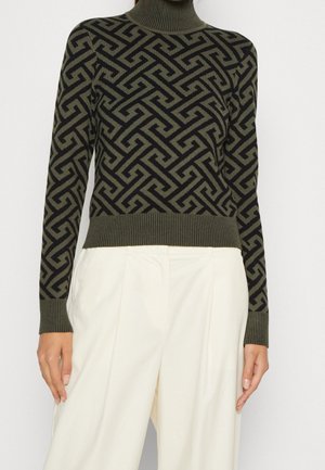 Maglione a collo alto verde oliva con un motivo geometrico nero. Polsini e orlo a coste, realizzato in un morbido tessuto lavorato a maglia.