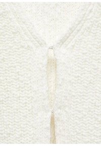 Cardigan blanc en tricot présentant un design texturé avec une ouverture sur le devant et une fermeture centrale par agrafe. Fil doux avec un motif de tissage épais.