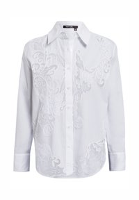 White button-up shirt with long sleeves. Features intricate white embroidery design covering the front. Classic collar and rounded hem.
