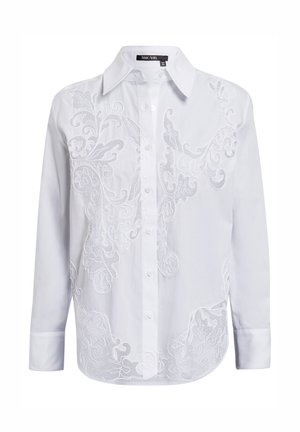 White button-up shirt with long sleeves. Features intricate white embroidery design covering the front. Classic collar and rounded hem.
