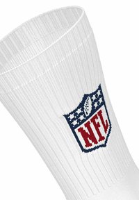 Calzino bianco a coste con il logo NFL a forma di scudo, con un pallone da football e stelle in rosso, bianco e blu sul lato.