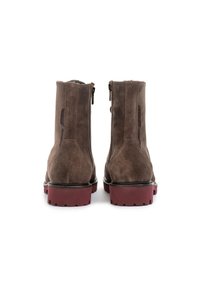 Brown suede ankle boots with a side zipper, flat red sole, and a smooth finish. Features a rounded toe and subtle branding on the heel.