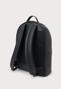 Svart ryggsekk med en glatt syntetisk overflate og polstret mesh-bak. Har polstrede stropper og et subtilt teksturert mønster. Glidelåsdetalj synlig.