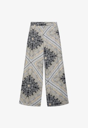 Pantaloni a gamba larga con motivi paisley intricati beige, neri e bianchi e motivi geometrici a quadrato, con una vita piatta.