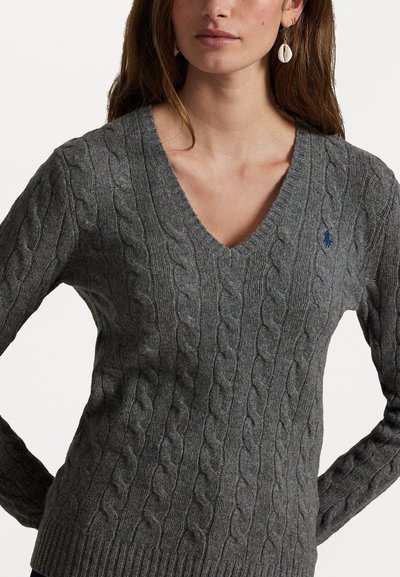 Γκρι πουλόβερ με πλέξη καλωδίου και σχεδιασμό με V στη λαιμόκοψη. Διαθέτει υφασμένους σχεδιασμούς και ριμπ μανσέτες. Μικρό μπλε λογότυπο στο στήθος.