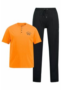 Pomarańczowa koszula z krótkim rękawem z kołnierzykiem henley oraz czarne spodnie ze sznurkiem w talii z bocznymi kieszeniami i zwężającym się krojem nogawek.
