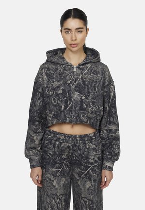 Felpa a maniche lunghe con cappuccio e pantaloni coordinati in un motivo camouflage nero e grigio, caratterizzati da una chiusura con zip e un tessuto morbido e testurizzato.