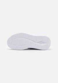 Semelle de sneaker en caoutchouc blanc avec des motifs de grip texturés et des caractéristiques de soutien. Profil plat avec un bout arrondi et des éléments de design minimaux.