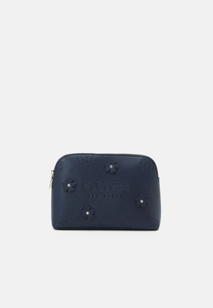 Marineblaues Ted Baker Täschchen mit eingeprägten Blumen und Text "EST. 1988 TED BAKER," mit Reißverschluss oben.