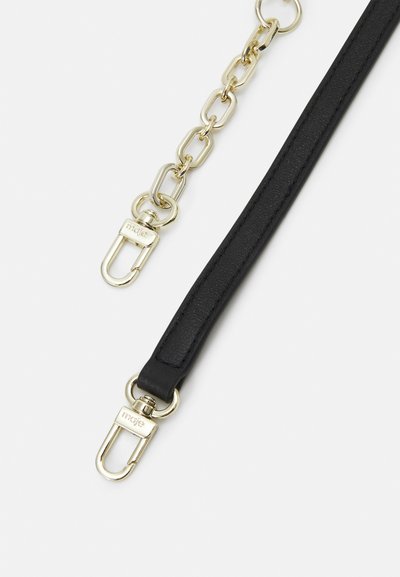 Schwarzes Lederband mit einer goldenen Kette und Beschlägen, mit Clip-Befestigungen, die eine elegante, glatte Textur und ein poliertes Finish präsentieren.