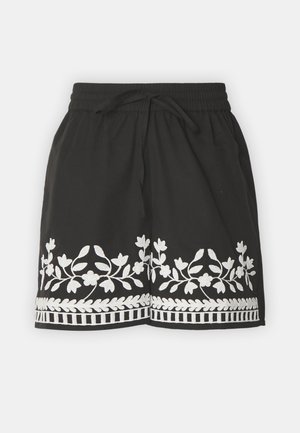 Schwarze Shorts mit weißer Blumenstickerei und -besatz. Mit einem Kordelzug-Hosenträger und leichtem Stoff, ideal für legere Anlässe.