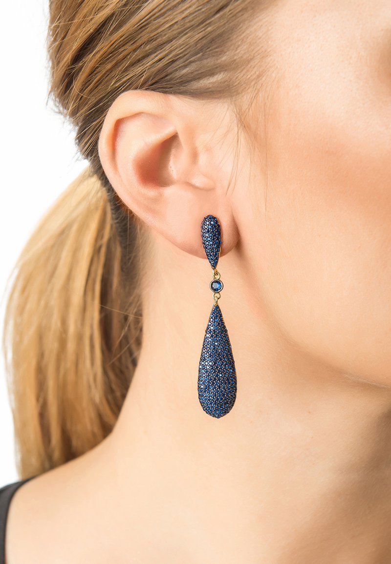 Blue teardrop earrings with a textured surface, featuring a glittery finish and a small accent stone set in gold-tone hardware.